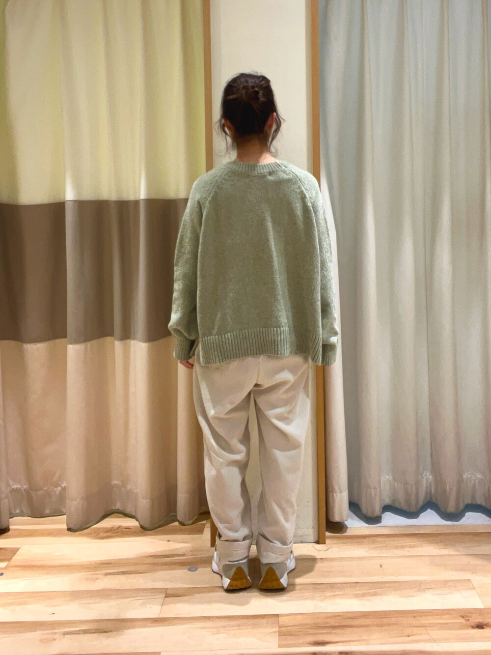 グリーン系のニット/セーター、ホワイト系のその他パンツを着用したレディースの冬コーディネートの4枚目の写真