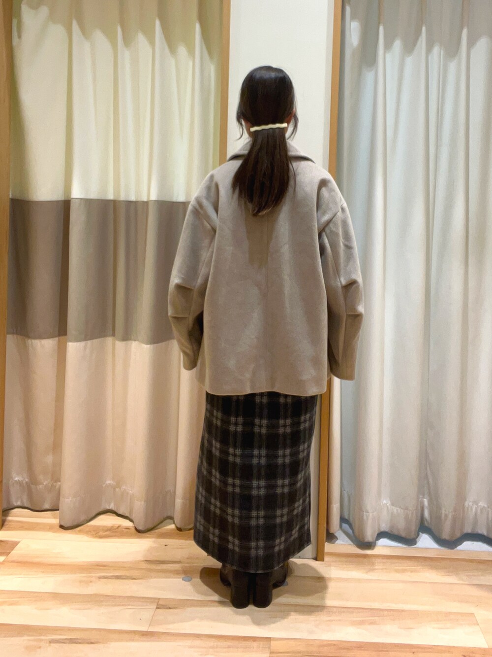 ベージュ系のその他アウター、ブルー系のスカート、ブラック系のドレスシューズを着用したレディースの秋コーディネートの4枚目の写真