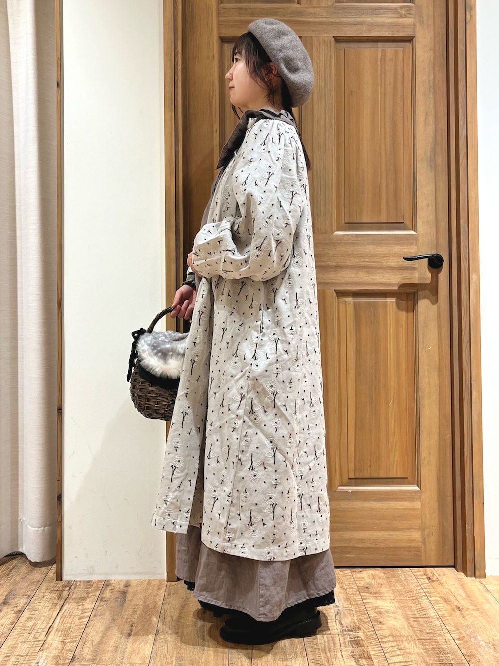 ブラウン系のバッグ、ブラック系のブーツ、グレー系のワンピースを着用したレディースの秋コーディネートの2枚目の写真