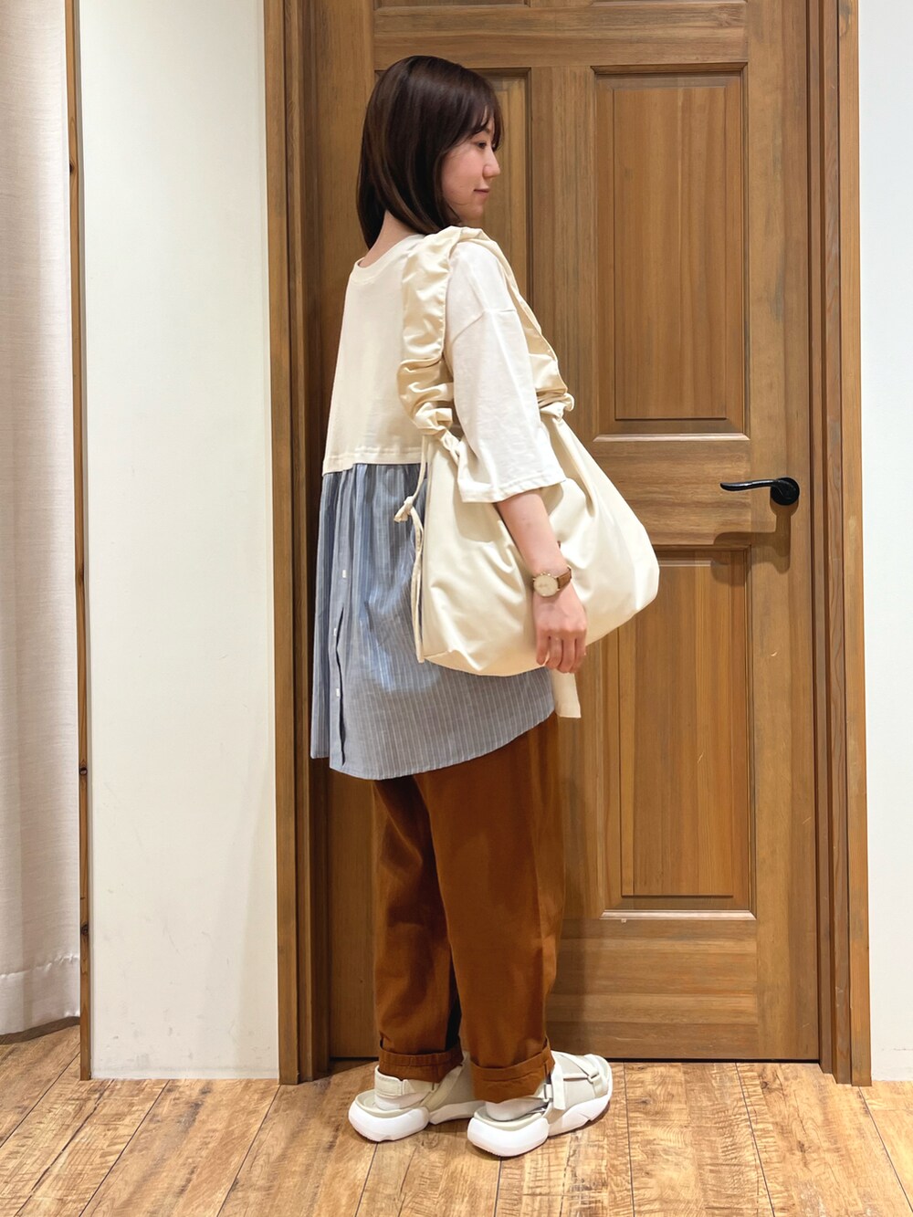 ホワイト系のハンドバッグ、ブラウン系のその他パンツ、ベージュ系のサンダルを着用したレディースの夏コーディネートの5枚目の写真