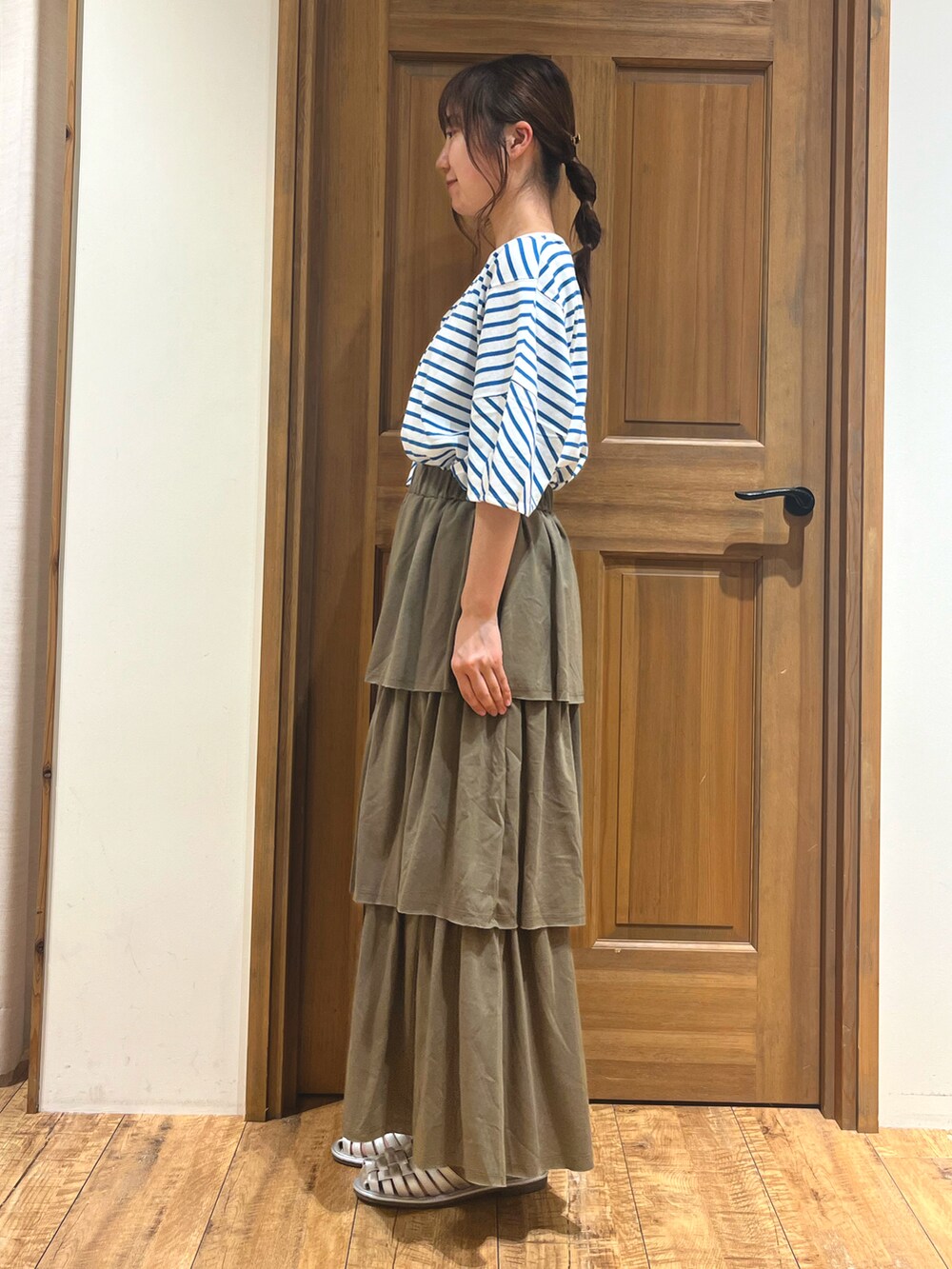 シルバー系のサンダル、ブルー系のTシャツ/カットソー、グリーン系のスカートを着用したレディースの夏コーディネートの5枚目の写真