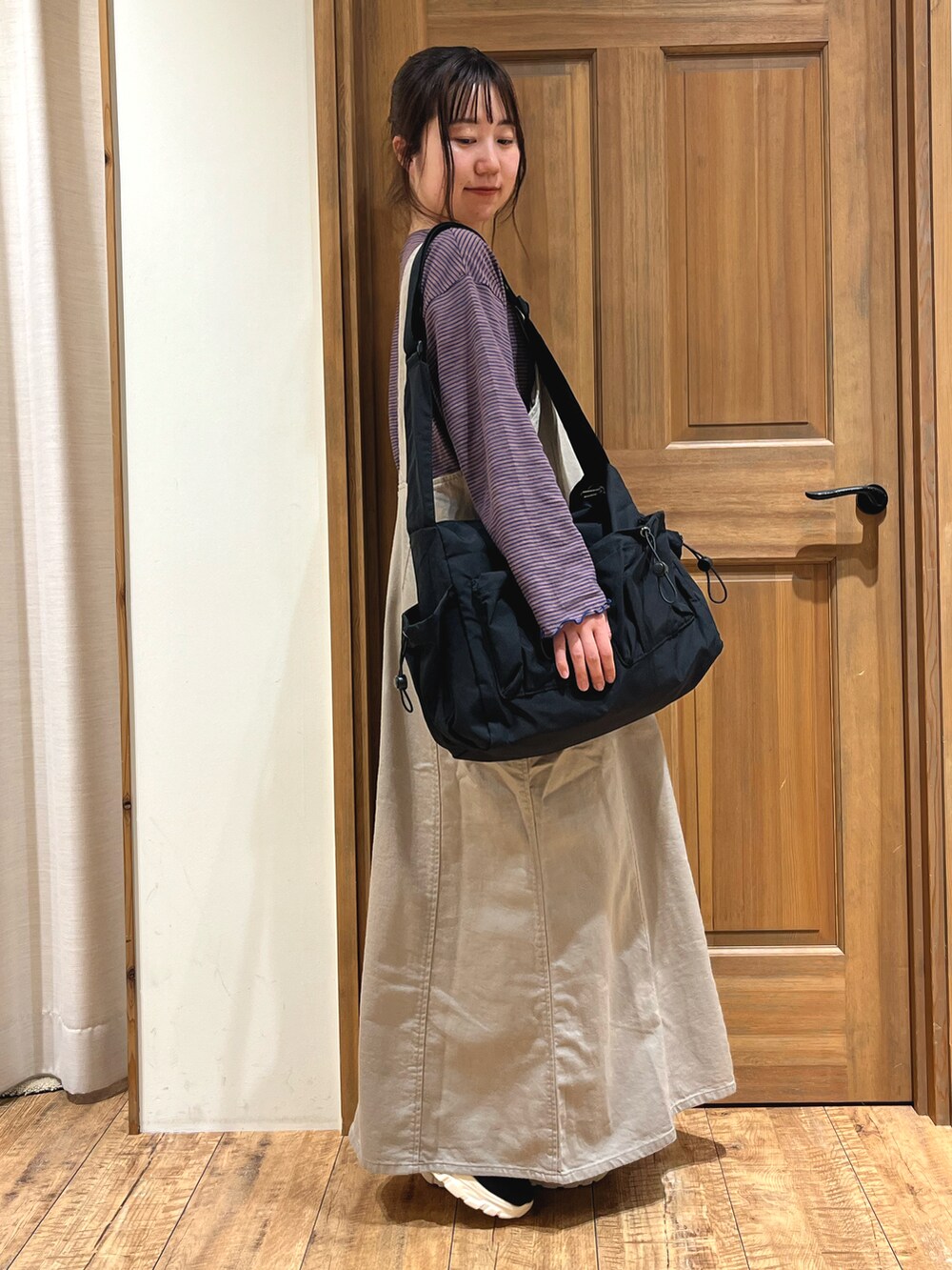 ブラック系のドレスシューズ、ブラック系のハンドバッグ、ベージュ系のワンピースを着用したレディースの秋コーディネートの2枚目の写真