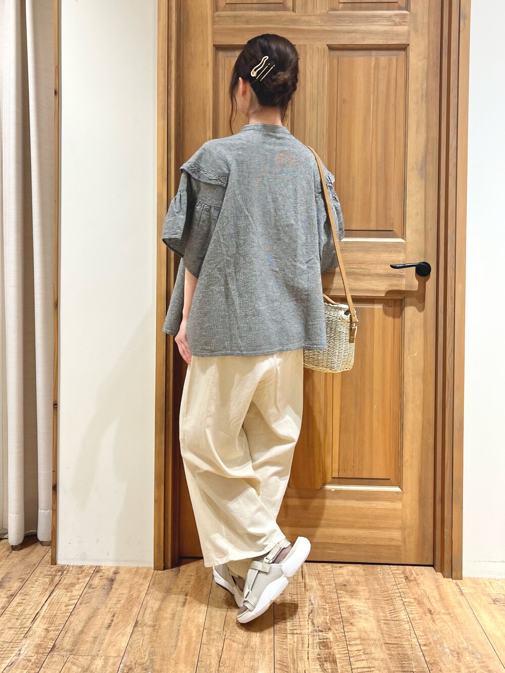 ホワイト系のハンドバッグ、グレー系のシャツ/ブラウス、ホワイト系のその他パンツを着用したレディースの夏コーディネートの3枚目の写真