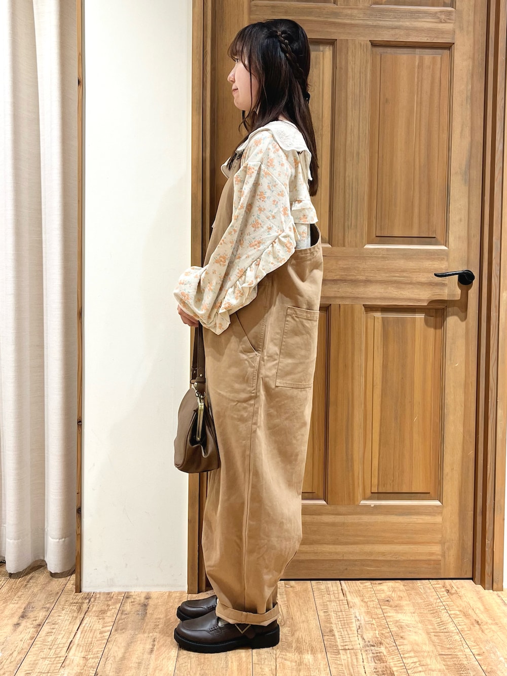 ブラウン系のハンドバッグ、ホワイト系のシャツ/ブラウス、ホワイト系のTシャツ/カットソーを着用したレディースの秋コーディネートの3枚目の写真