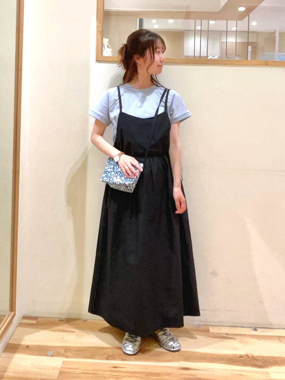 ブルー系のハンドバッグ、ブラック系のワンピース、ブルー系のTシャツ/カットソーを着用したレディースの春コーディネートの2枚目の写真