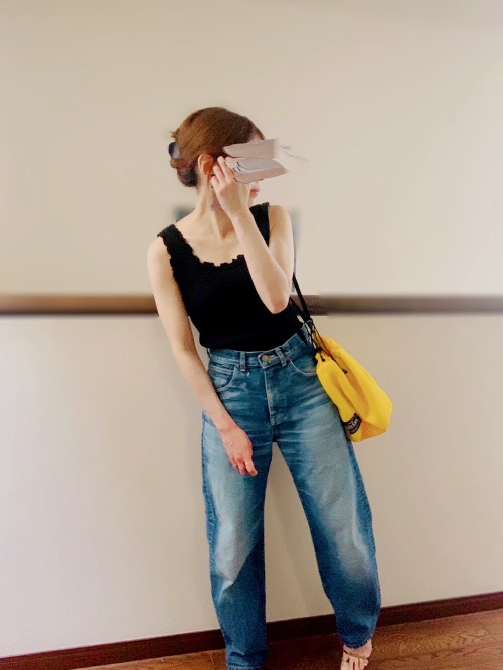 ブラック系のタンクトップ、ブルー系のデニムパンツ、ブラウン系のサンダルを着用したレディースの夏コーディネートの3枚目の写真