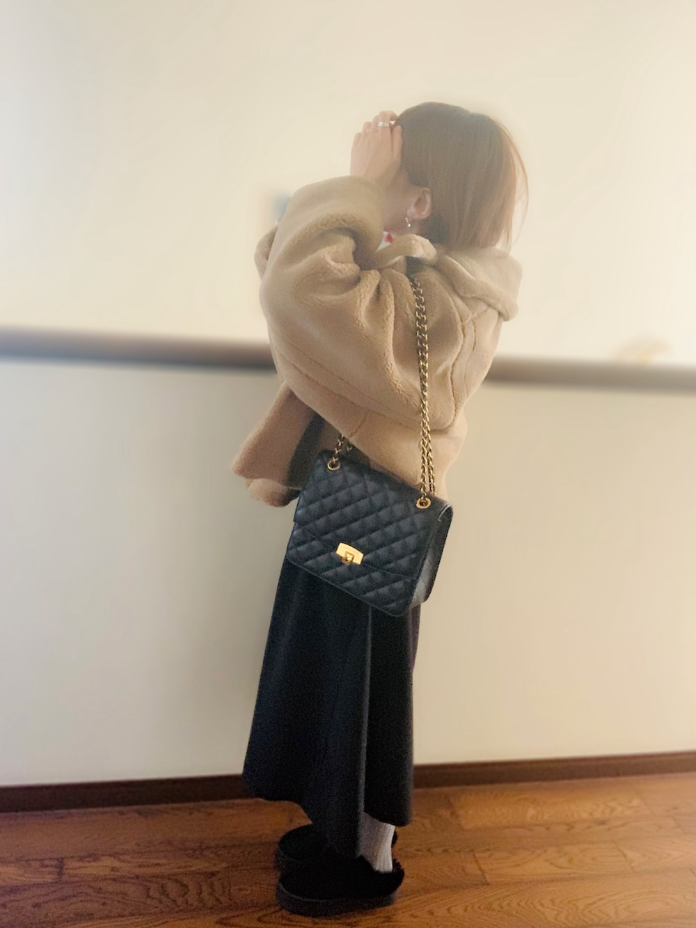 ブラウン系のその他アウター、ブラック系のスカート、ブラック系のクラッチバッグを着用したレディースの冬コーディネートの2枚目の写真