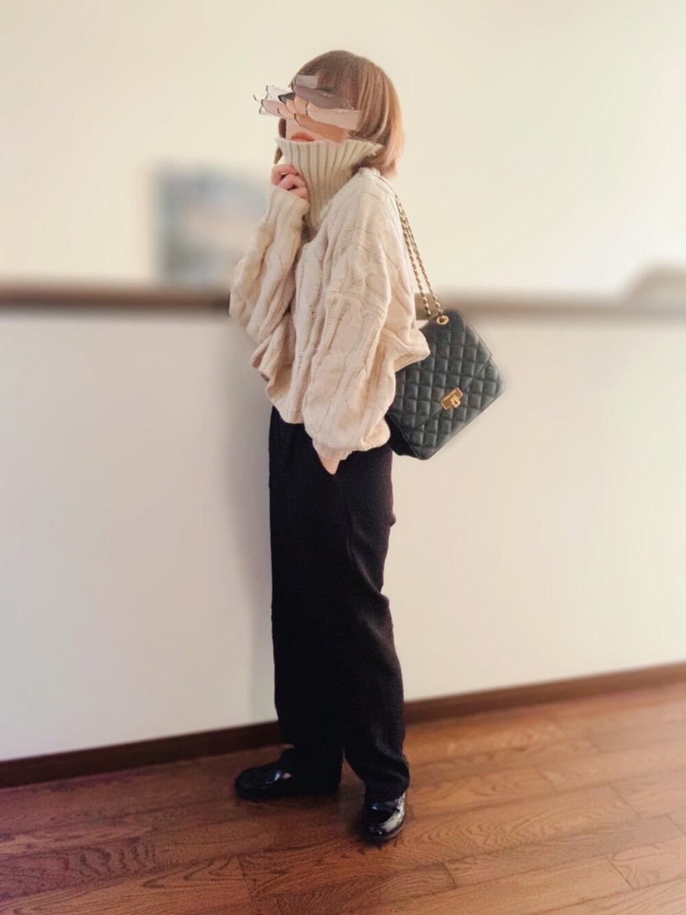 ホワイト系のニット/セーター、ブラック系のクラッチバッグ、ブラック系のスラックスを着用したレディースの冬コーディネートの2枚目の写真