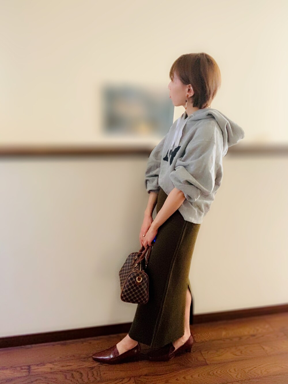 ブラウン系のボストンバッグ、グリーン系のスカート、ブラウン系のローファーを着用したレディースの秋コーディネートの2枚目の写真