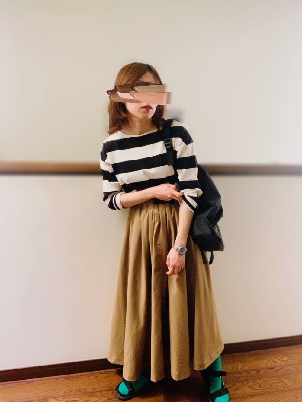 ベージュ系のスカート、ブラック系のサンダル、グリーン系のソックス/靴下を着用したレディースの春コーディネートの2枚目の写真