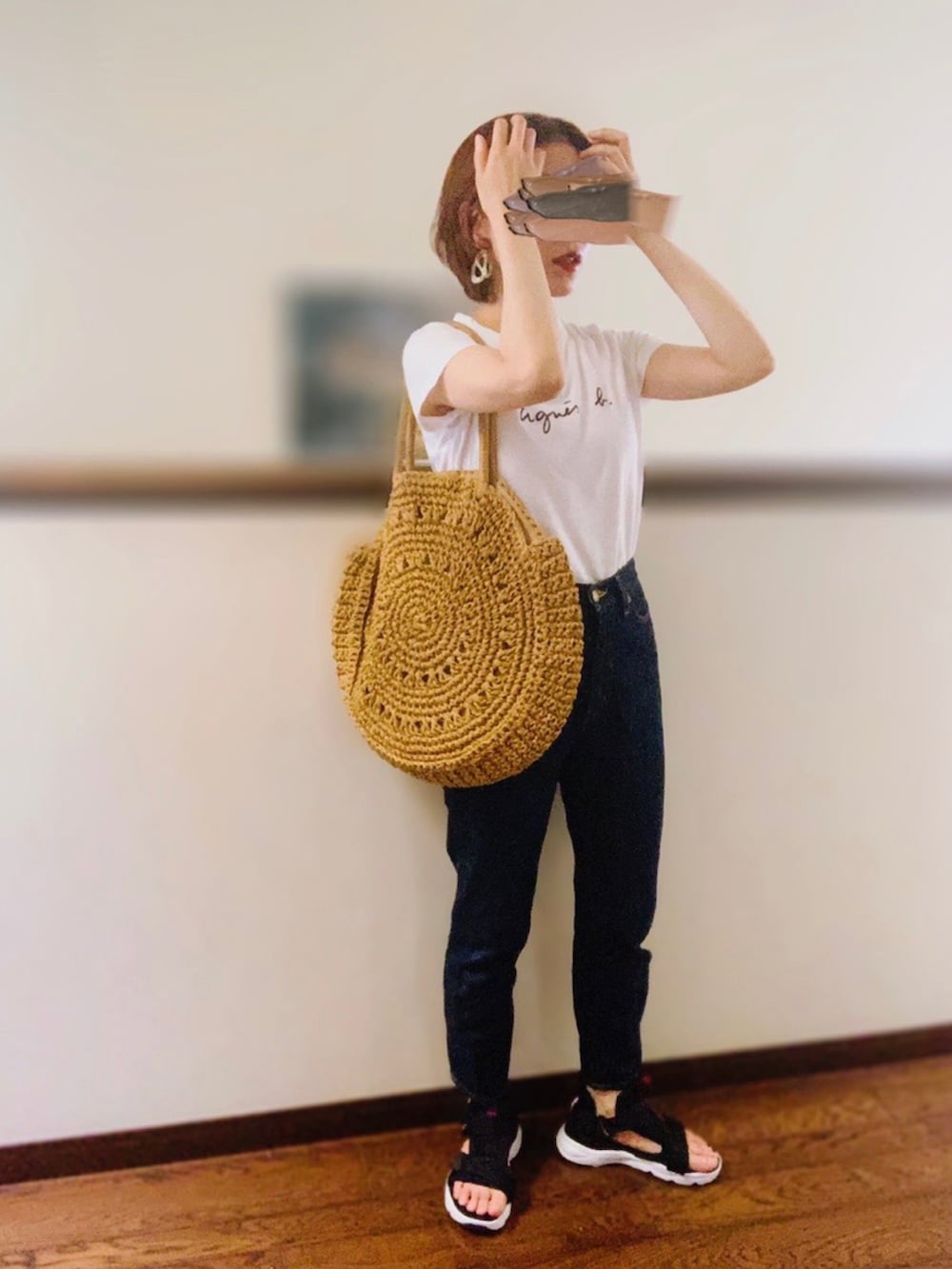 ホワイト系のTシャツ/カットソー、ブルー系のデニムパンツ、ベージュ系のトートバッグを着用したレディースの夏コーディネートの2枚目の写真