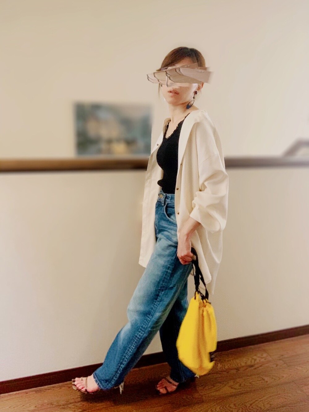 ブラック系のタンクトップ、ブルー系のデニムパンツ、ブラウン系のサンダルを着用したレディースの夏コーディネートの2枚目の写真