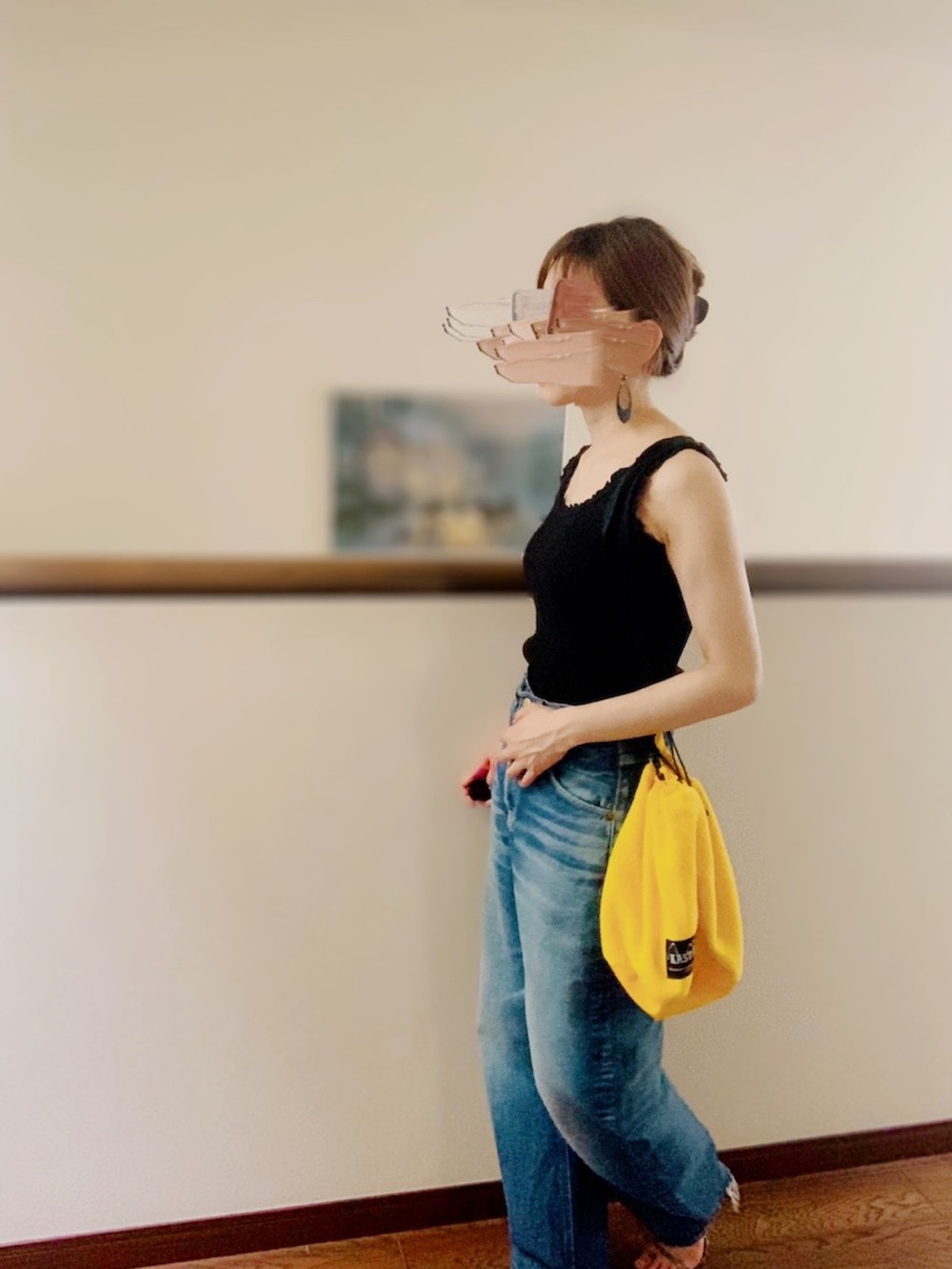 ブラック系のタンクトップ、ブルー系のデニムパンツ、ブラウン系のサンダルを着用したレディースの夏コーディネートの4枚目の写真