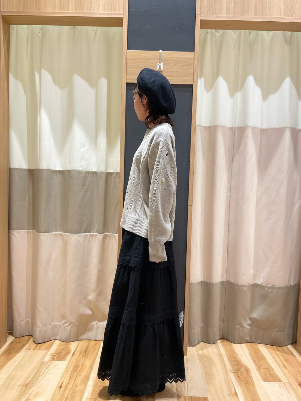 ブラウン系のニット/セーター、ブラック系のスカート、ブラック系のハットを着用したレディースの秋コーディネートの2枚目の写真