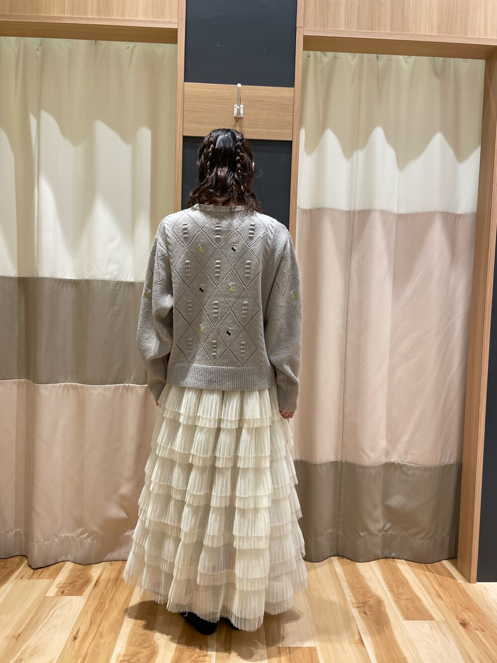 ブラウン系のニット/セーター、ホワイト系のスカートを着用したレディースの秋コーディネートの5枚目の写真