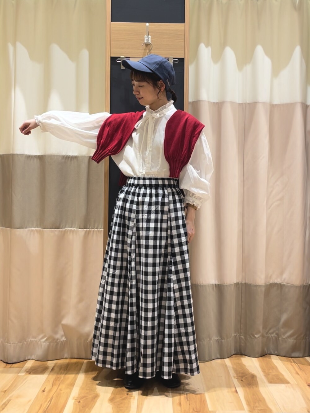 レッド系のカーディガン/ボレロ、ホワイト系のシャツ/ブラウス、ブラック系のスカートを着用したレディースの春コーディネートの2枚目の写真