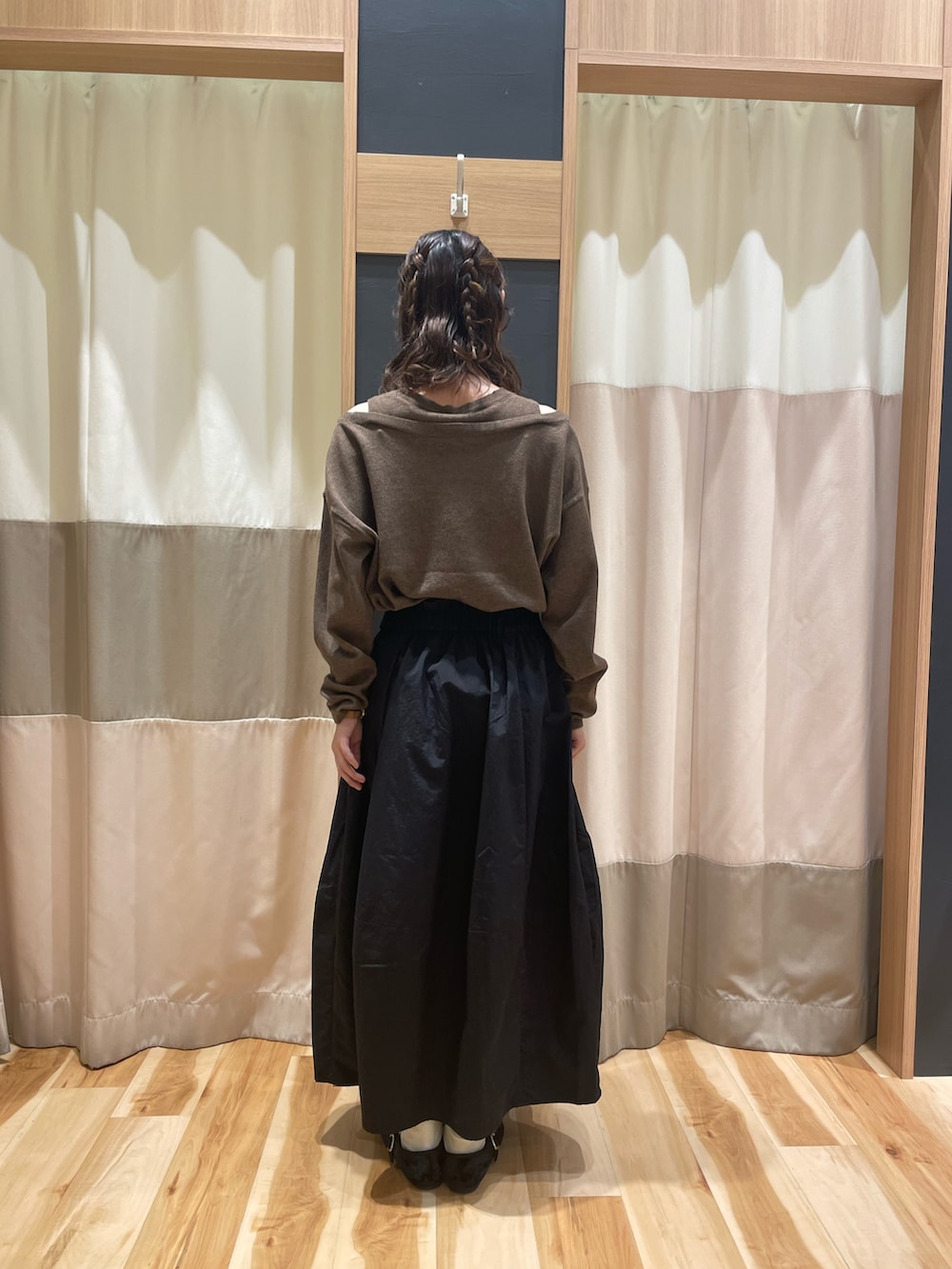 ブラウン系のニット/セーター、ブラック系のスカートを着用したレディースの秋コーディネートの3枚目の写真