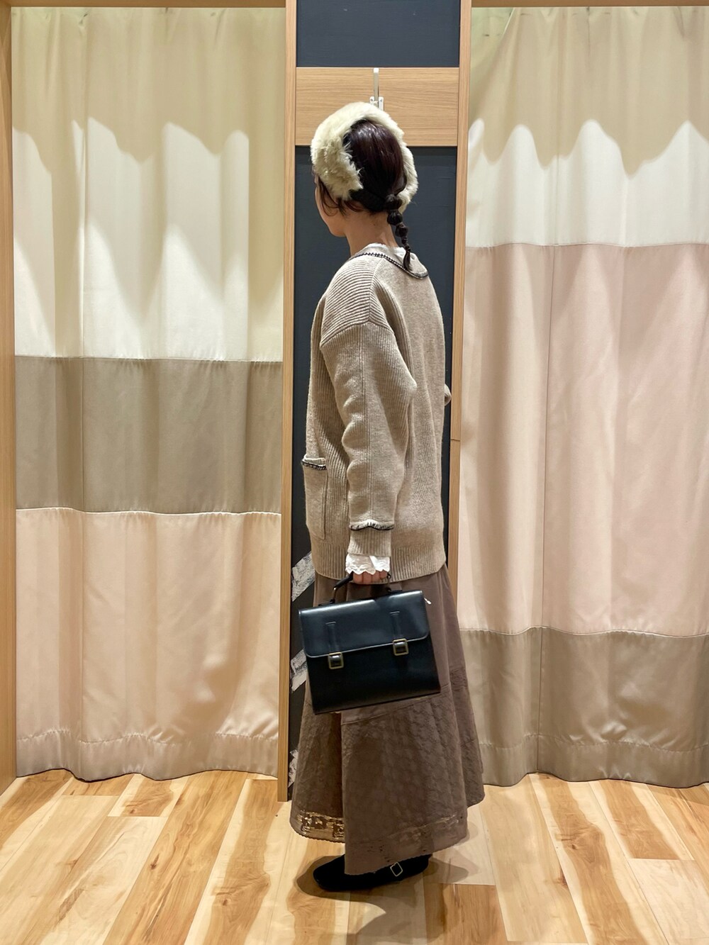 ホワイト系のシャツ/ブラウス、ブラウン系のスカート、ブラック系のハンドバッグを着用したレディースの冬コーディネートの2枚目の写真