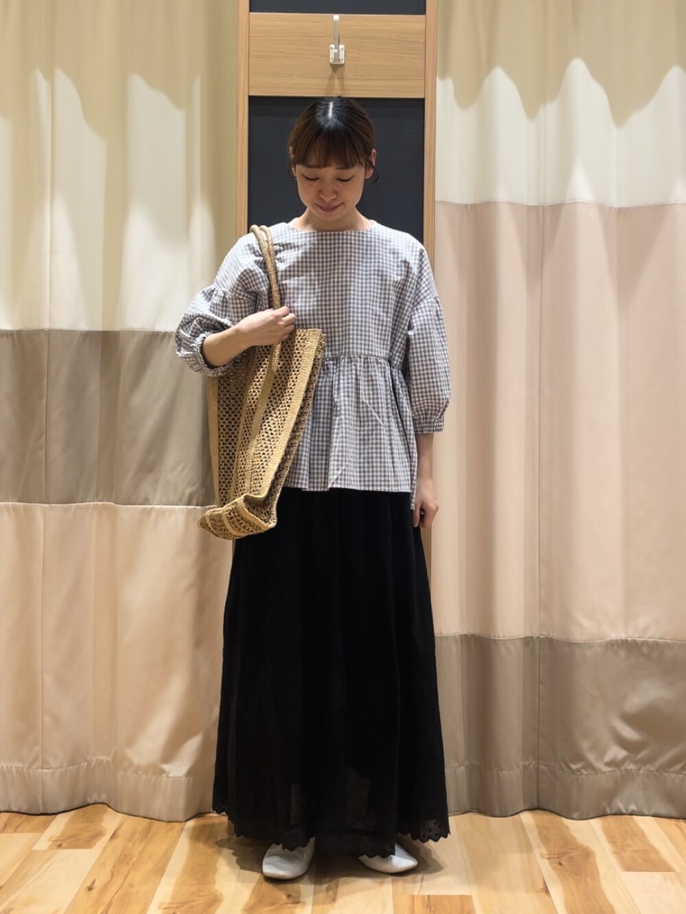 グレー系のシャツ/ブラウス、ブラック系のスカート、ベージュ系のハンドバッグを着用したレディースの春コーディネートの2枚目の写真