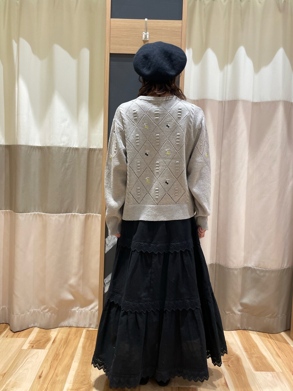 ブラウン系のニット/セーター、ブラック系のスカート、ブラック系のハットを着用したレディースの秋コーディネートの3枚目の写真