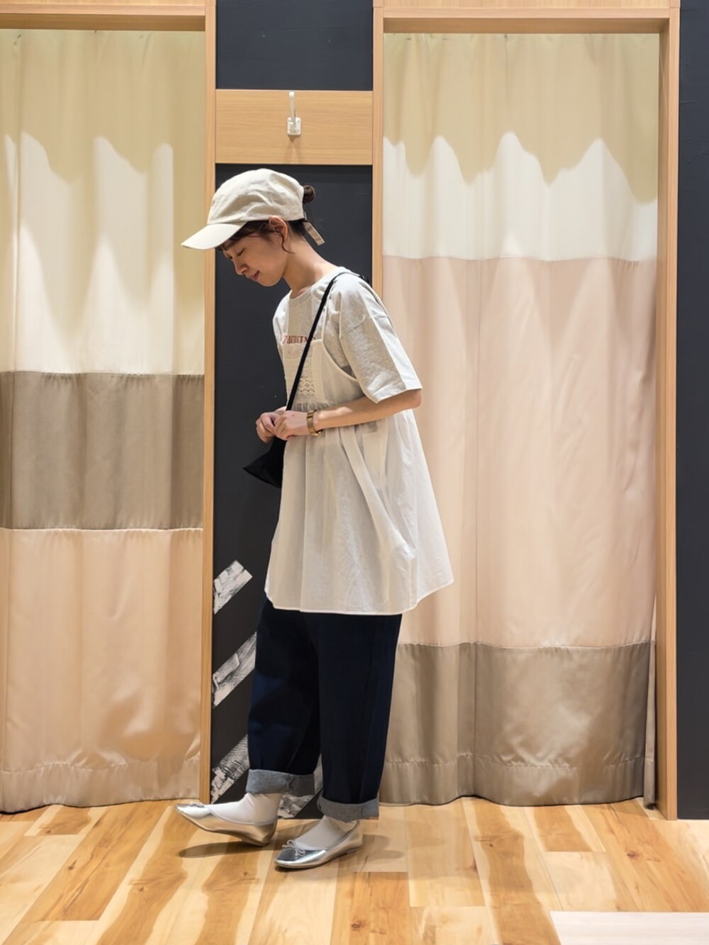 シルバー系のパンプス、ホワイト系のチュニック、グレー系のTシャツ/カットソーを着用したレディースの春コーディネートの2枚目の写真