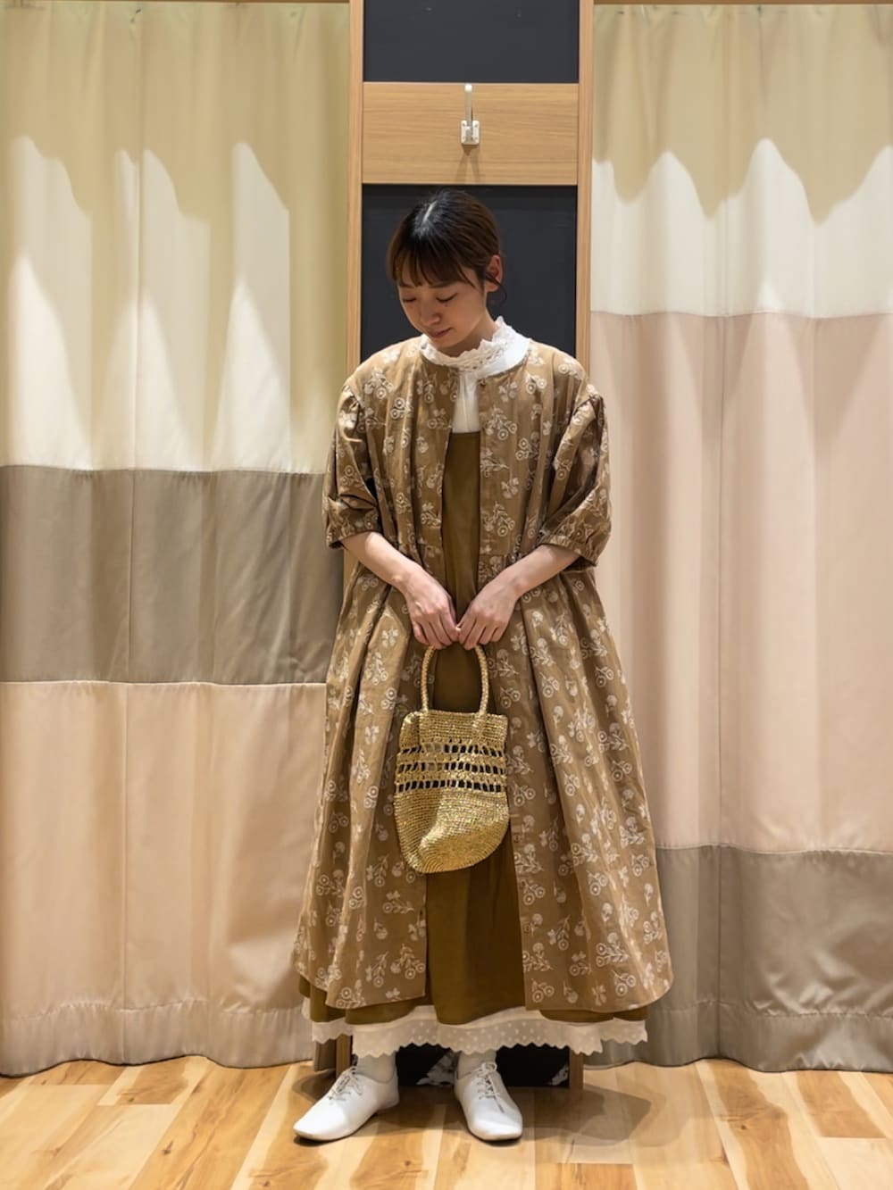 ホワイト系のTシャツ/カットソー、ベージュ系のワンピース、イエロー系のワンピースを着用したレディースの春コーディネートの2枚目の写真