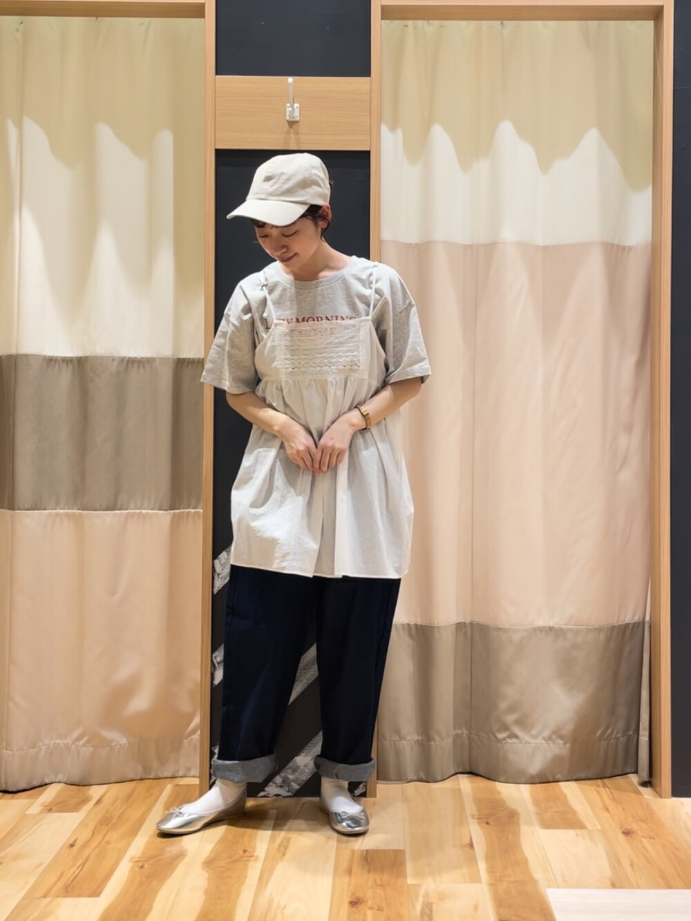 シルバー系のパンプス、ホワイト系のチュニック、グレー系のTシャツ/カットソーを着用したレディースの春コーディネートの4枚目の写真