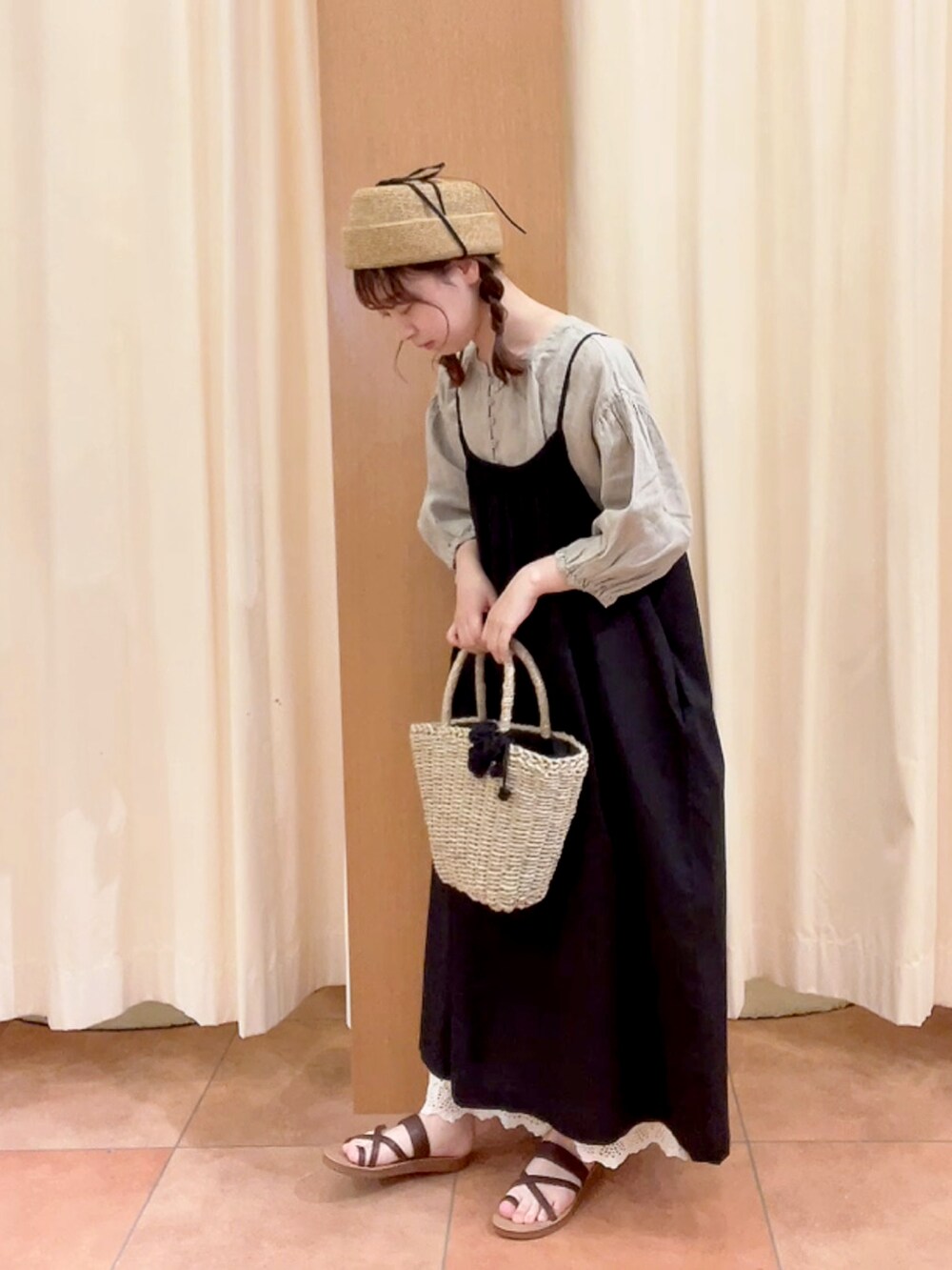 ホワイト系のかごバッグ、ブラック系のワンピース、ベージュ系のその他パンツを着用したレディースの夏コーディネートの2枚目の写真