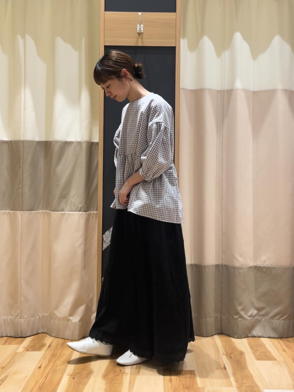 グレー系のシャツ/ブラウス、ブラック系のスカート、ベージュ系のハンドバッグを着用したレディースの春コーディネートの3枚目の写真