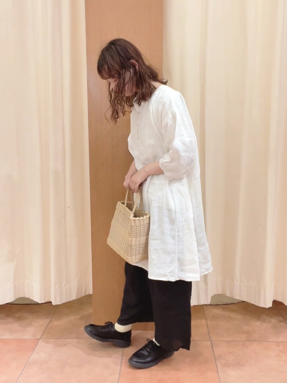 ベージュ系のトートバッグ、ブラック系のその他シューズ、ホワイト系のシャツ/ブラウスを着用したレディースの夏コーディネートの3枚目の写真