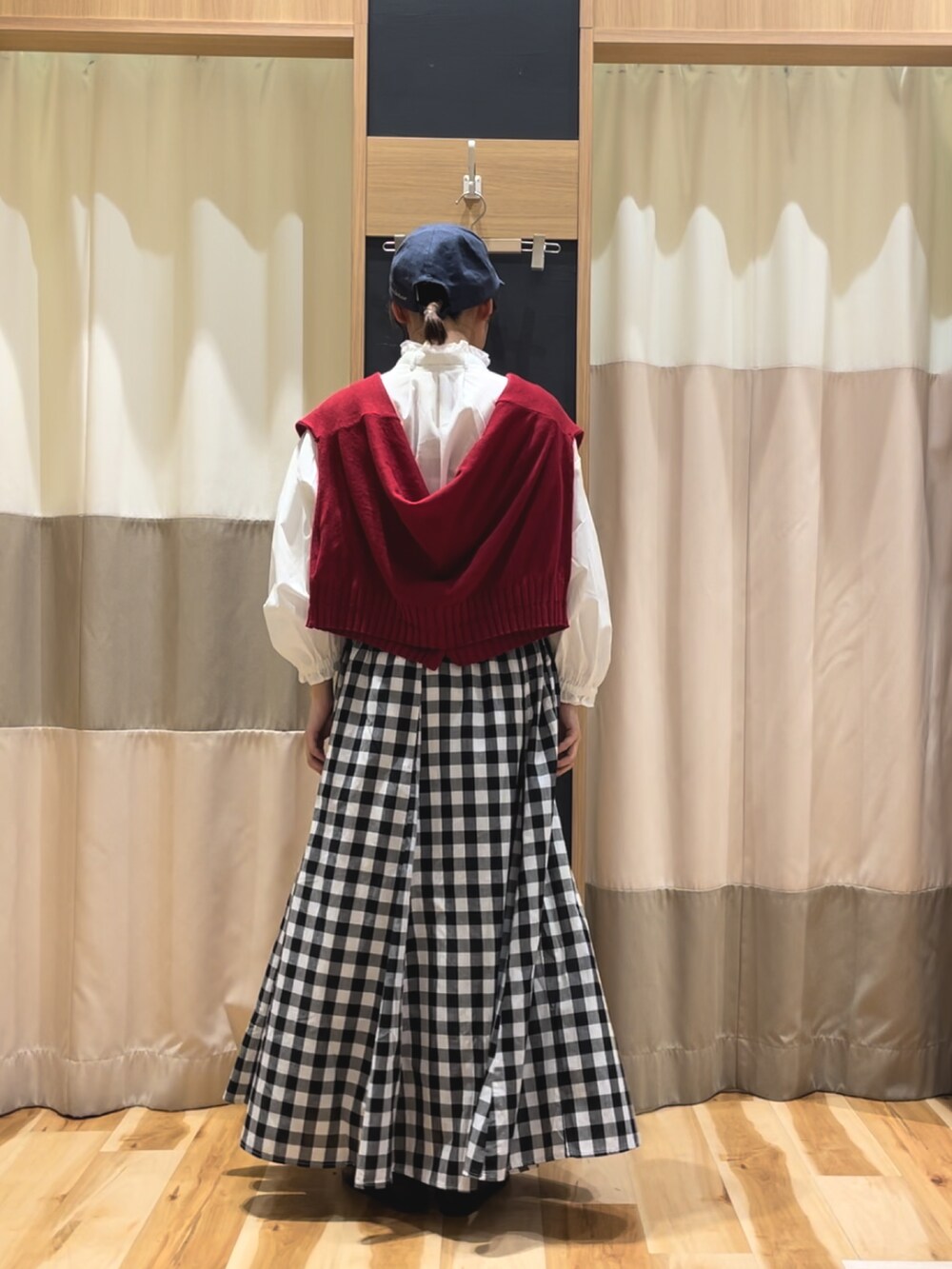 レッド系のカーディガン/ボレロ、ホワイト系のシャツ/ブラウス、ブラック系のスカートを着用したレディースの春コーディネートの4枚目の写真