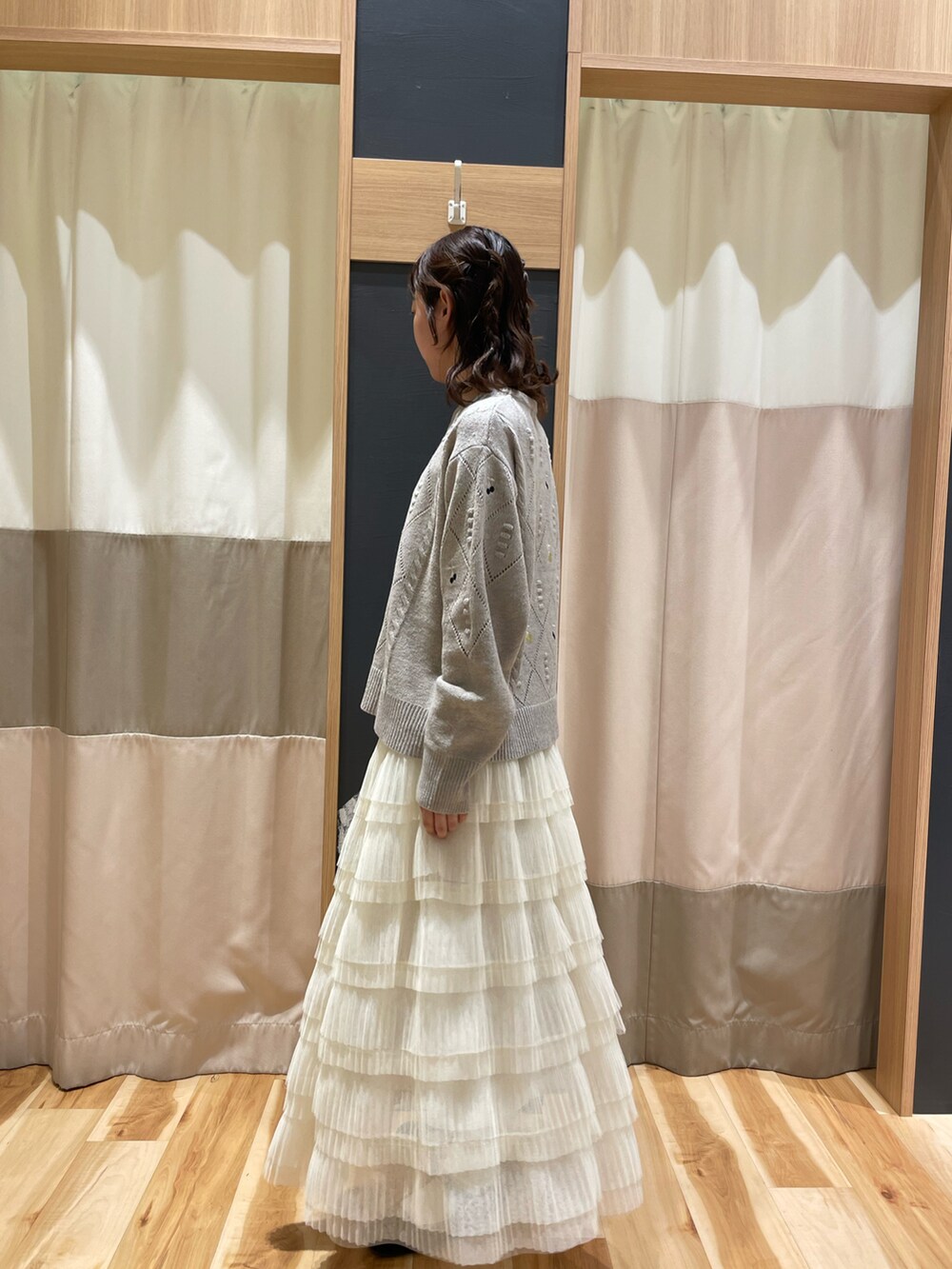 ブラウン系のニット/セーター、ホワイト系のスカートを着用したレディースの秋コーディネートの4枚目の写真