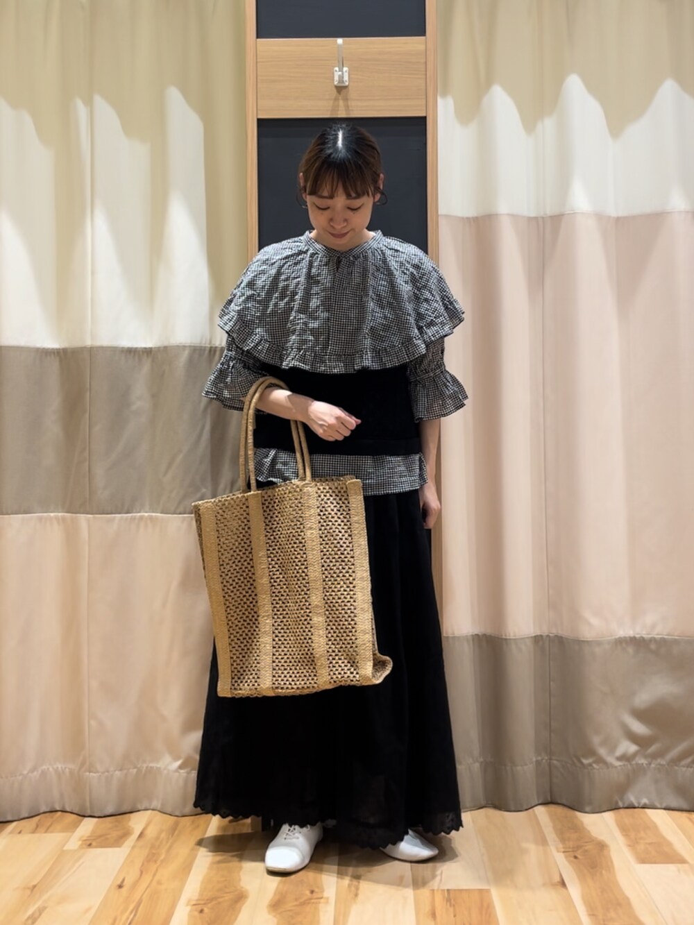 ベージュ系のハンドバッグ、ブラック系のシャツ/ブラウス、ブラック系のキャミソールを着用したレディースの春コーディネートの2枚目の写真