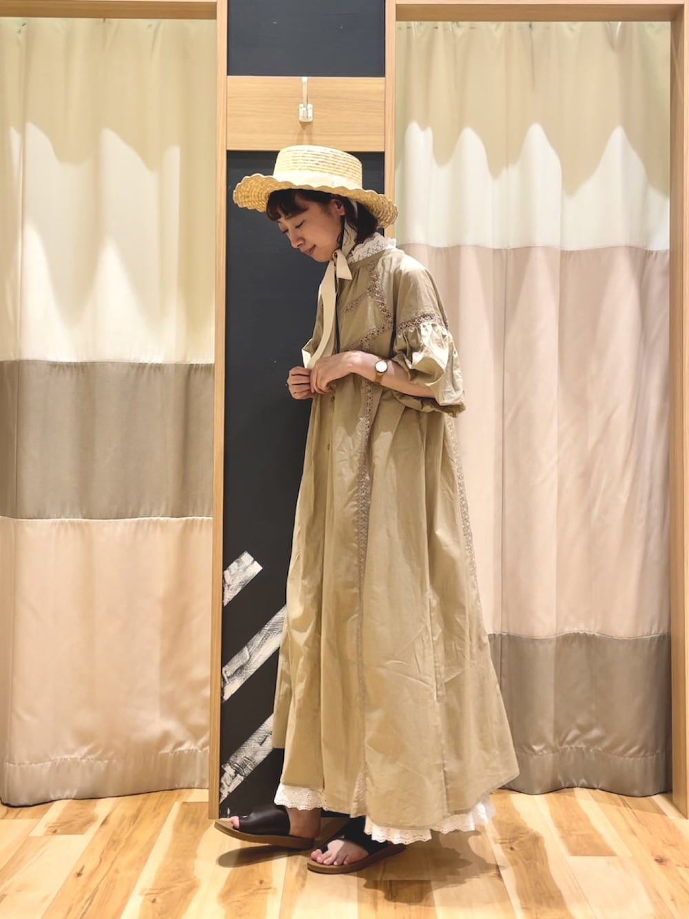 ブラウン系のサンダル、ベージュ系のワンピース、ホワイト系のTシャツ/カットソーを着用したレディースの夏コーディネートの2枚目の写真