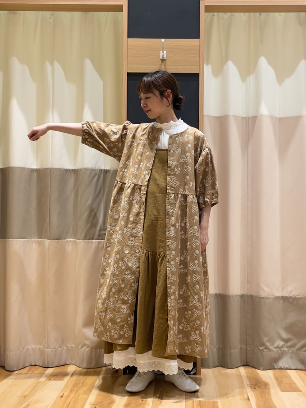 ホワイト系のTシャツ/カットソー、ベージュ系のワンピース、イエロー系のワンピースを着用したレディースの春コーディネートの3枚目の写真