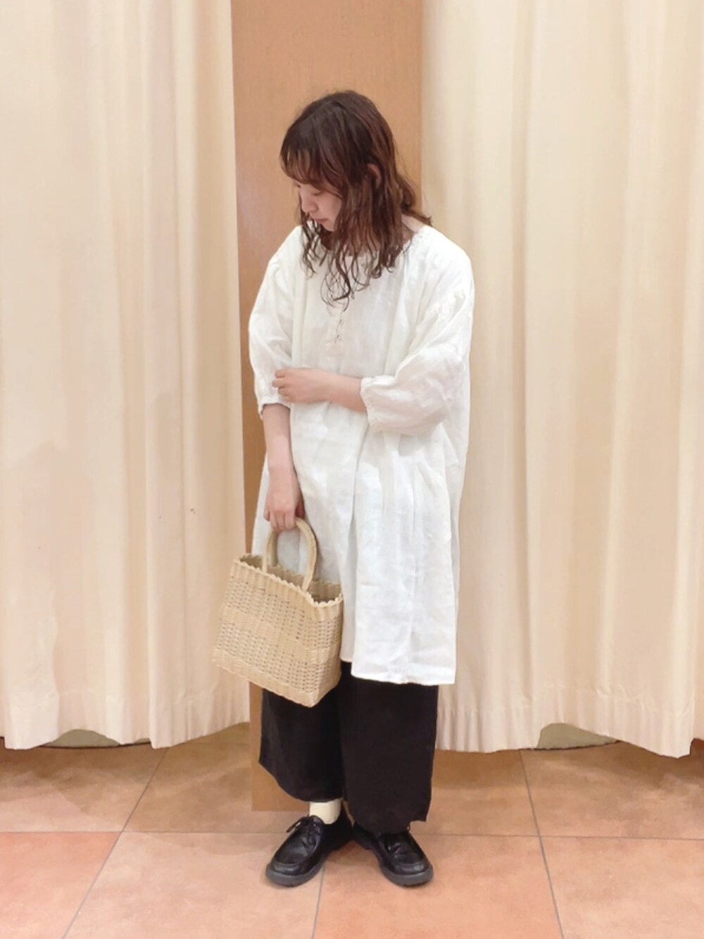 ベージュ系のトートバッグ、ブラック系のその他シューズ、ホワイト系のシャツ/ブラウスを着用したレディースの夏コーディネートの2枚目の写真