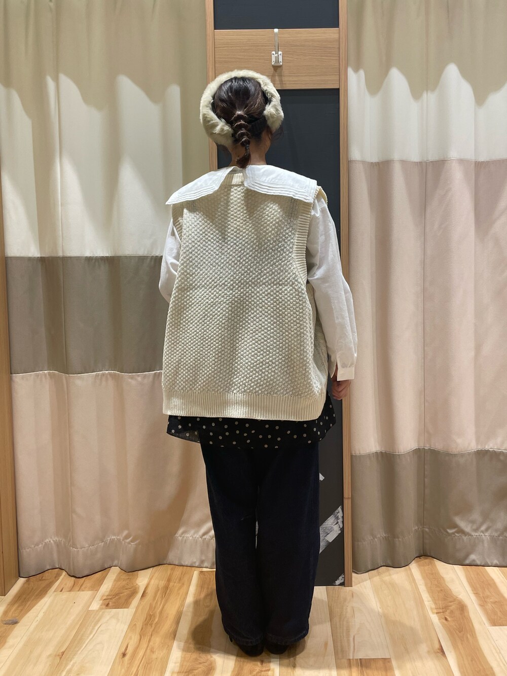 グレー系のシャツ/ブラウス、ホワイト系のベスト、ブラック系のチュニックを着用したレディースの秋コーディネートの3枚目の写真