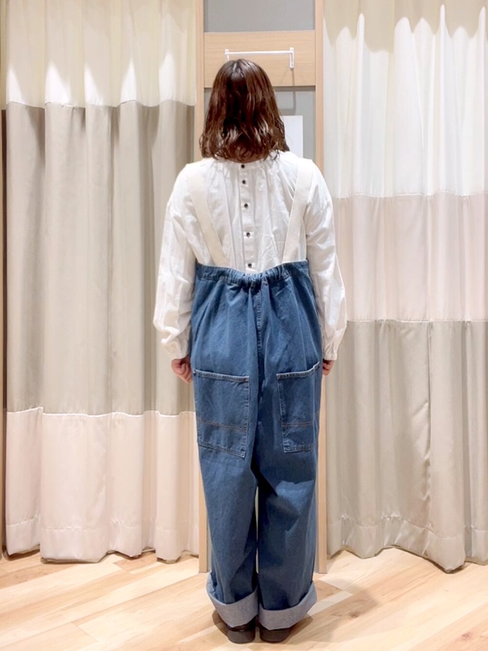 ブラック系のショルダーバッグ、ホワイト系のシャツ/ブラウス、ブルー系のサロペット/オーバーオールを着用したレディースの冬コーディネートの2枚目の写真