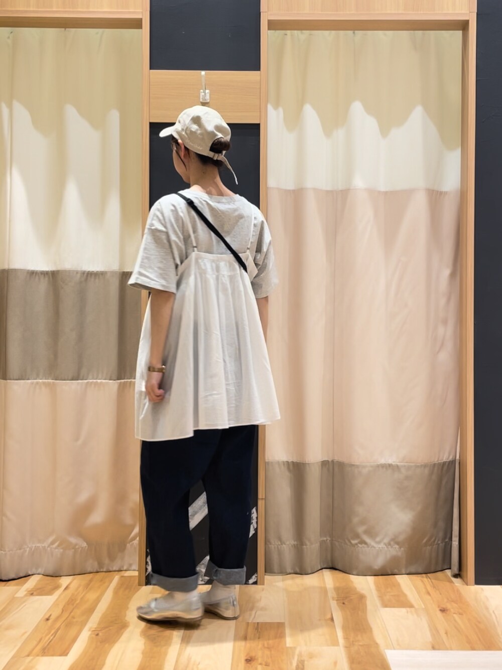 シルバー系のパンプス、ホワイト系のチュニック、グレー系のTシャツ/カットソーを着用したレディースの春コーディネートの3枚目の写真