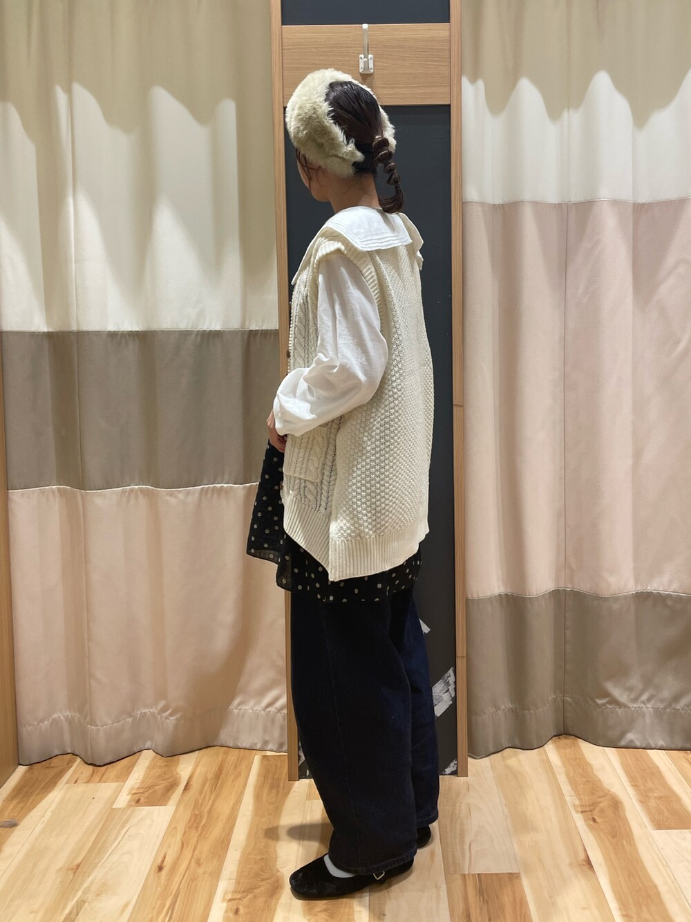 グレー系のシャツ/ブラウス、ホワイト系のベスト、ブラック系のチュニックを着用したレディースの秋コーディネートの2枚目の写真