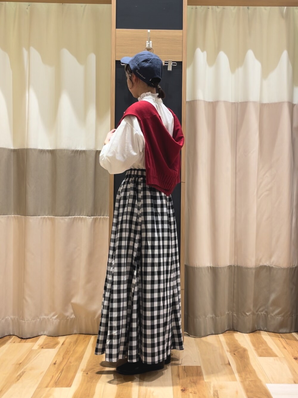 レッド系のカーディガン/ボレロ、ホワイト系のシャツ/ブラウス、ブラック系のスカートを着用したレディースの春コーディネートの3枚目の写真