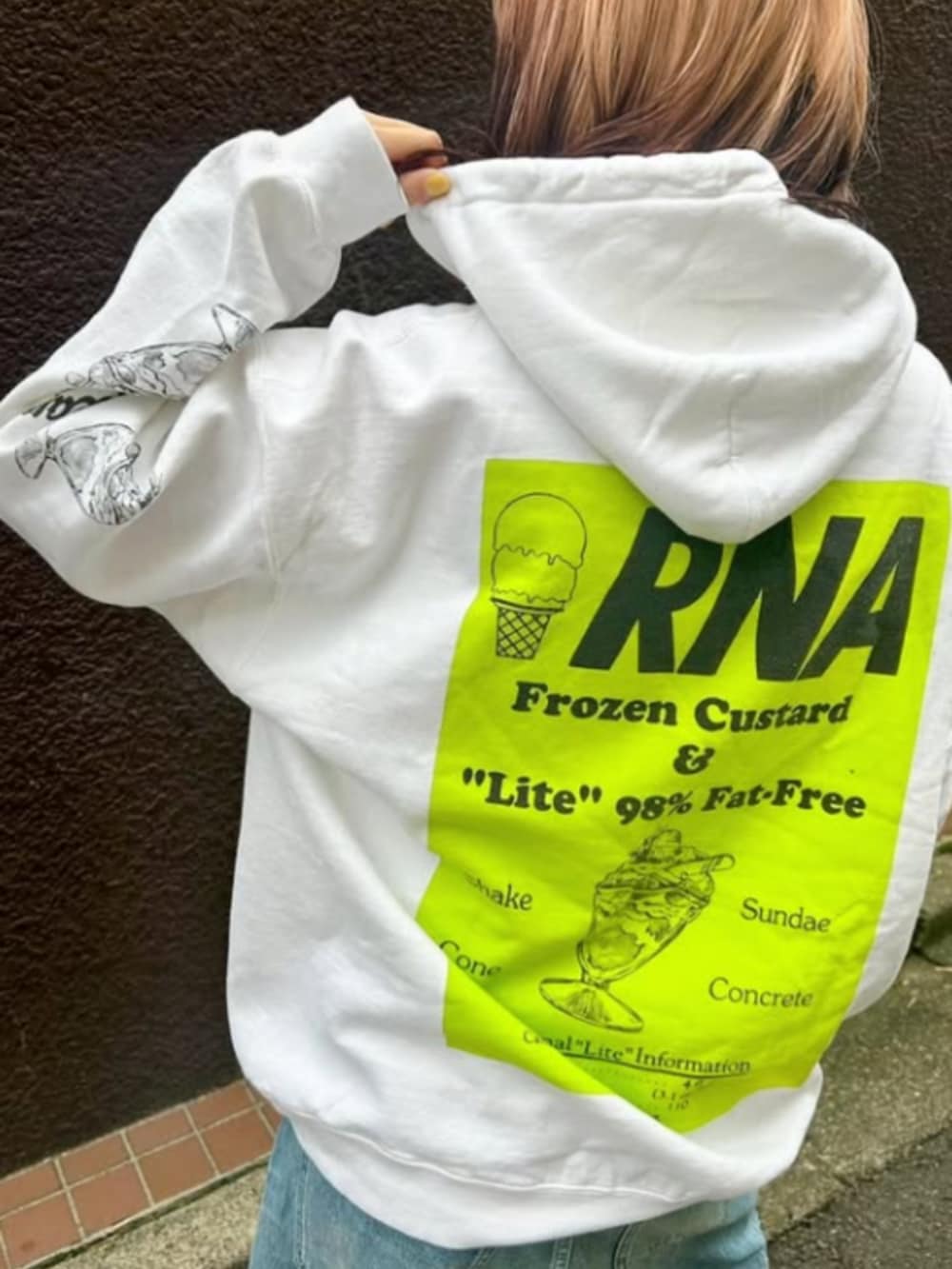 ブルー系のデニムパンツ、ホワイト系のパーカーを着用したレディースの秋コーディネートの2枚目の写真