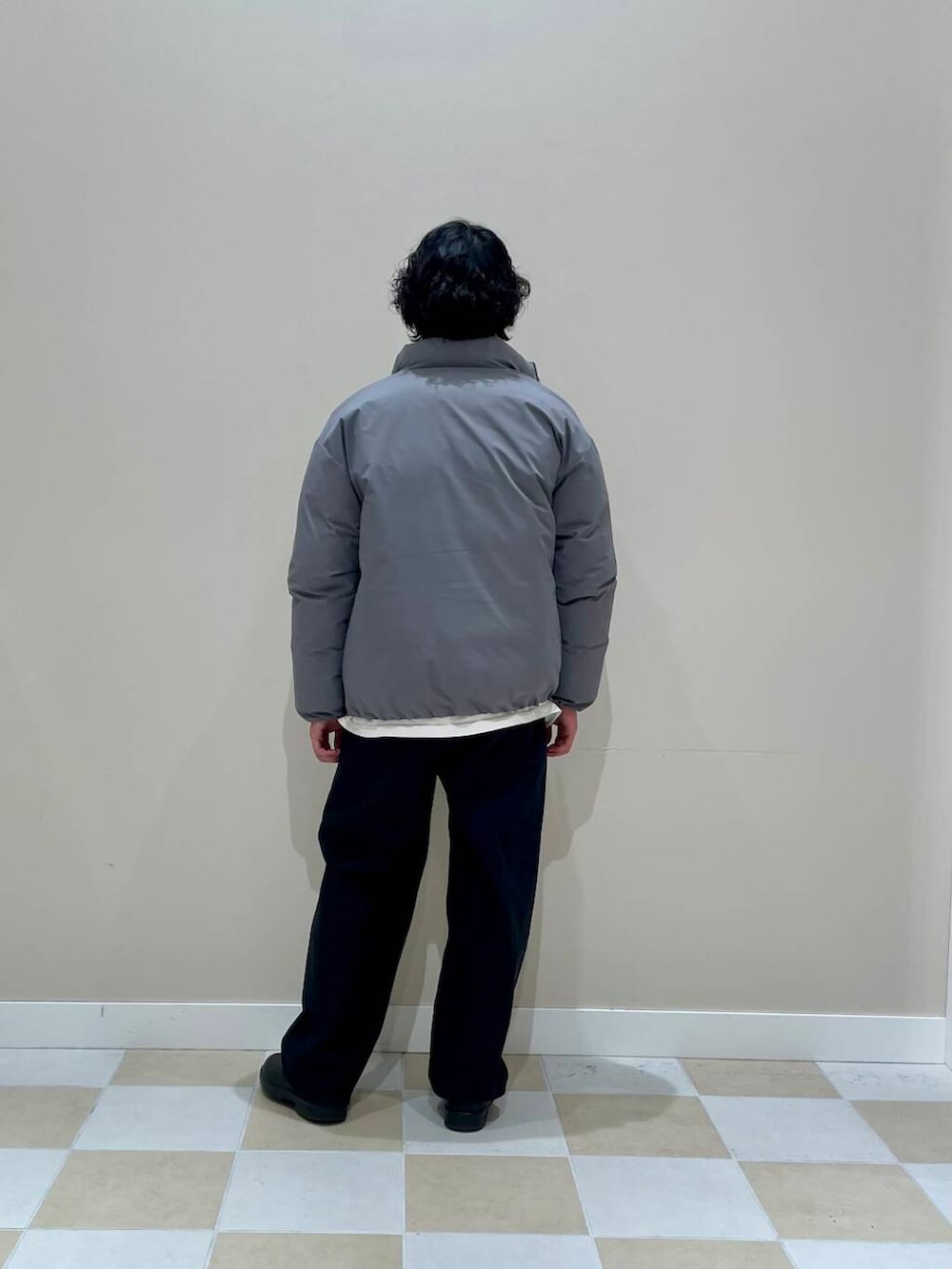 ベージュ系のニット/セーター、ブラック系のデニムパンツ、グレー系のダウンジャケット/コートを着用したメンズの冬コーディネートの3枚目の写真