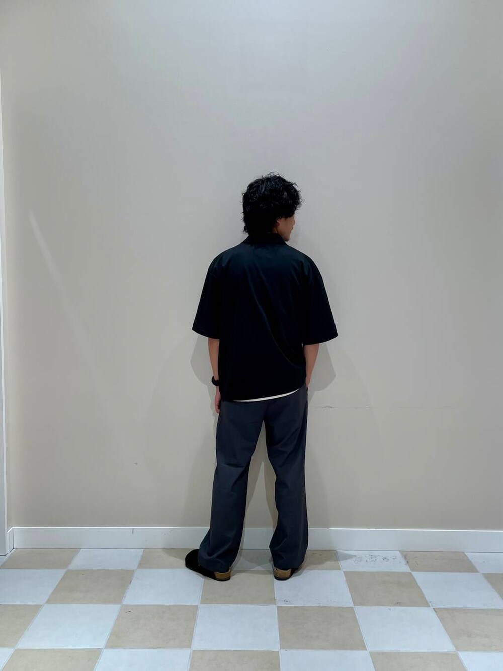 グレー系のスラックス、ブラック系のTシャツ/カットソーを着用したメンズの夏コーディネートの2枚目の写真