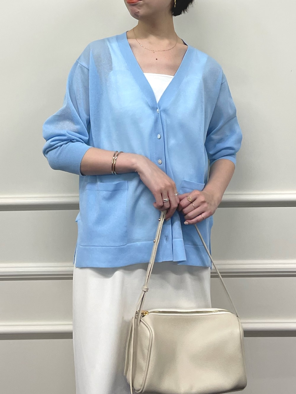 ブルー系のカーディガン/ボレロ、ホワイト系のキャミソール、ホワイト系のショルダーバッグを着用したレディースの夏コーディネートの3枚目の写真