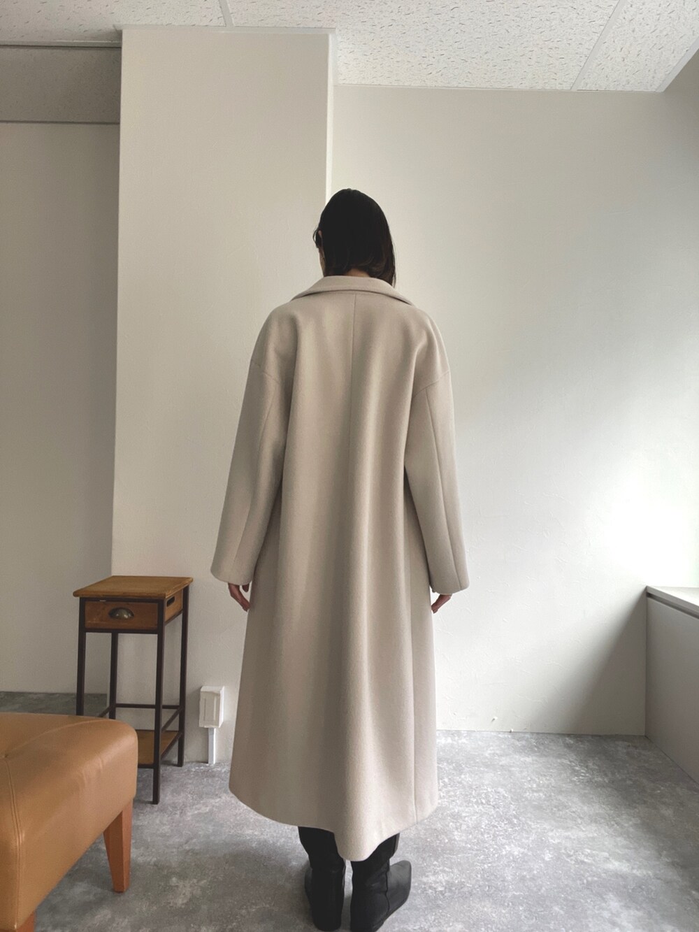 グレー系のニット/セーター、ベージュ系のチェスターコート、ブルー系のワンピースを着用したレディースの秋コーディネートの3枚目の写真