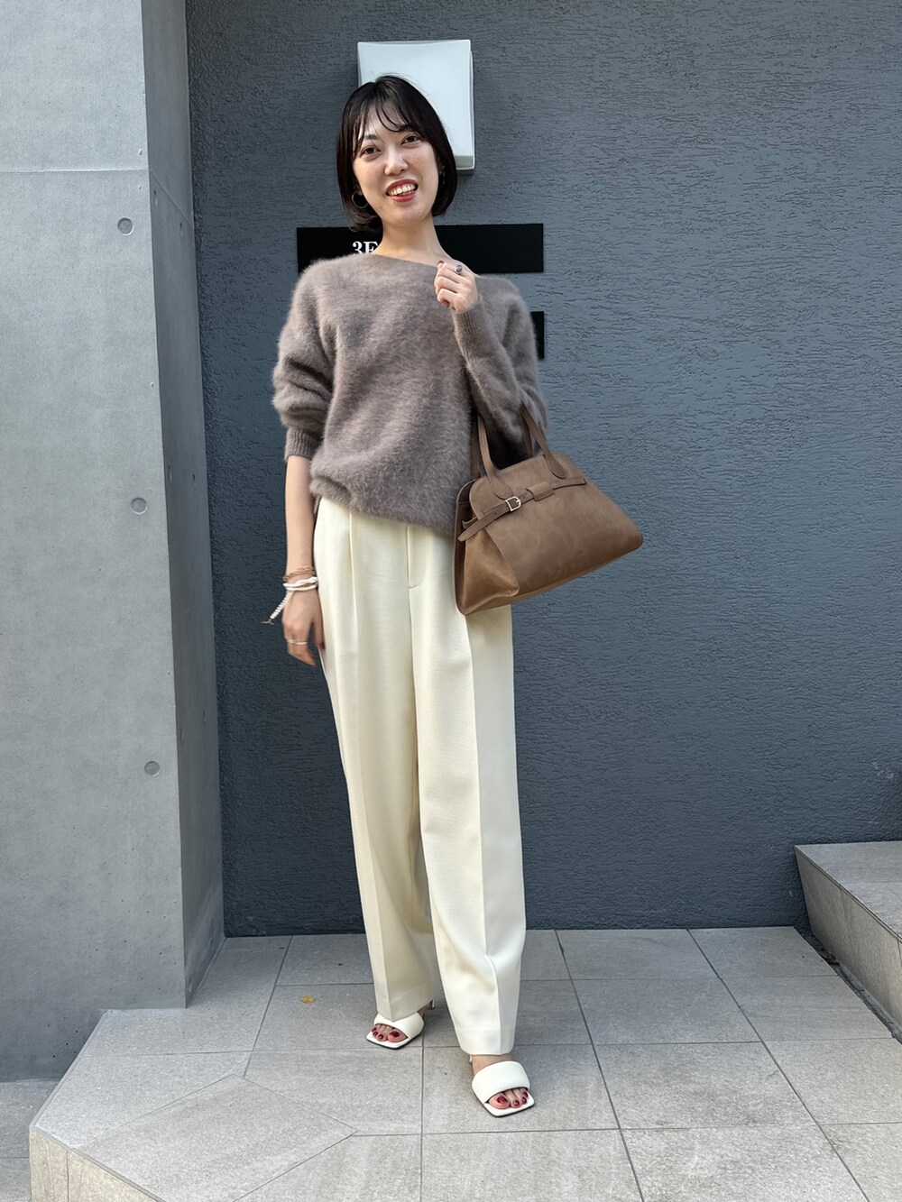 ブラウン系のニット/セーター、ブラウン系のボストンバッグ、ホワイト系のその他パンツを着用したレディースの秋コーディネートの3枚目の写真