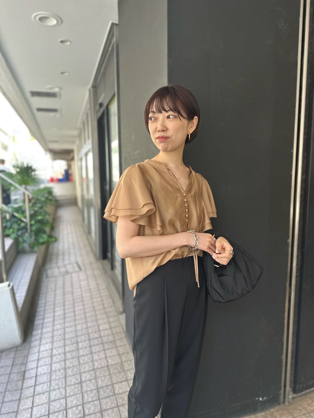 イエロー系のシャツ/ブラウス、ブラック系のその他パンツを着用したレディースの春コーディネートの3枚目の写真