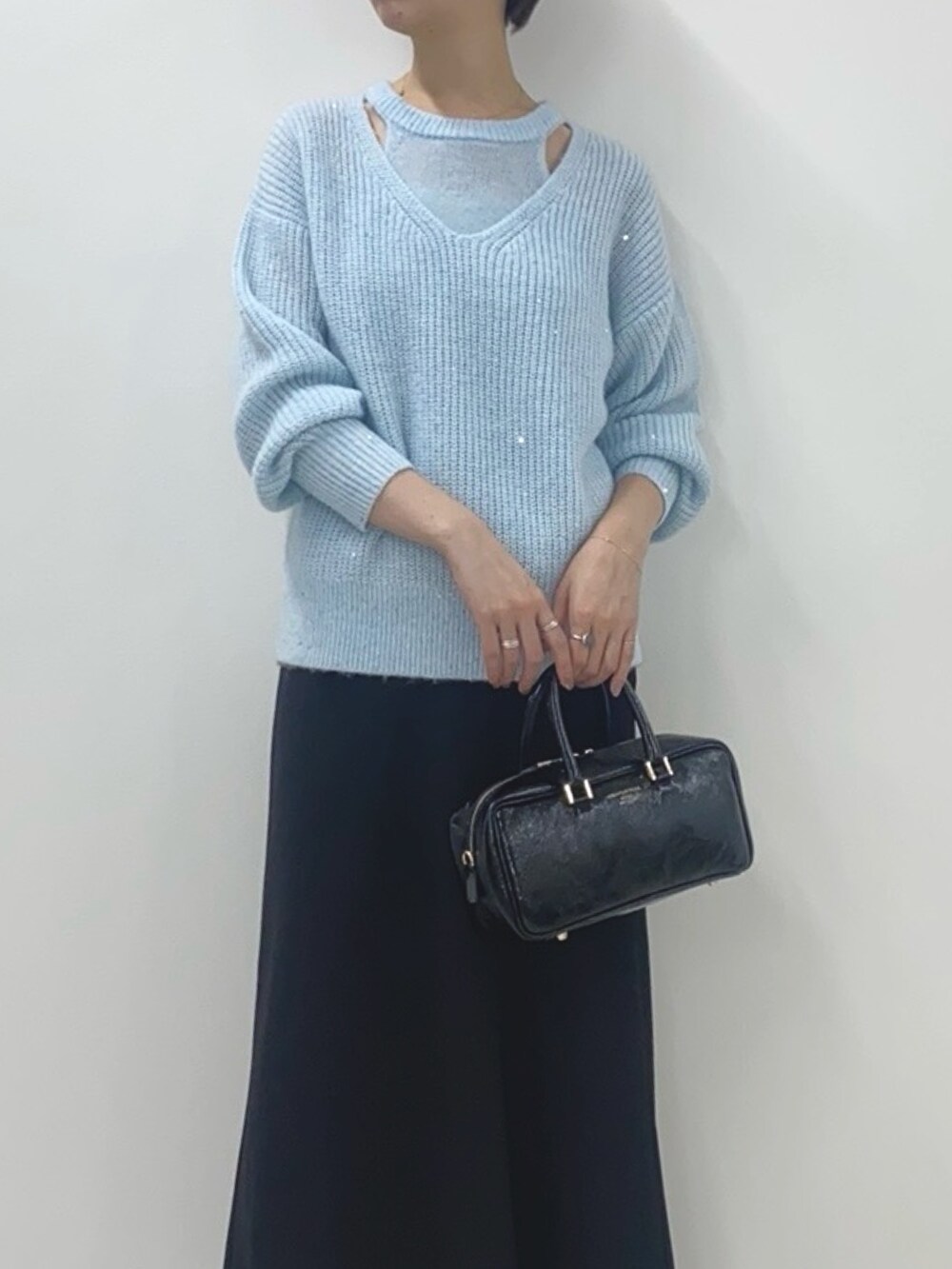 ブルー系のニット/セーター、ブラック系のスカート、ブラック系のボストンバッグを着用したレディースの冬コーディネートの5枚目の写真