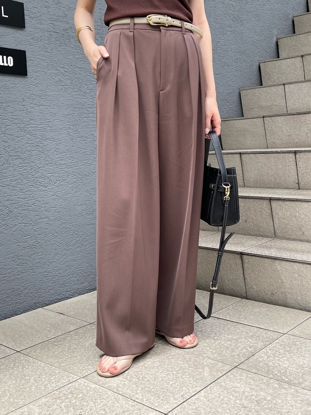 ブラウン系のニット/セーター、ブラウン系のその他パンツ、ベージュ系のベルトを着用したレディースの夏コーディネートの5枚目の写真